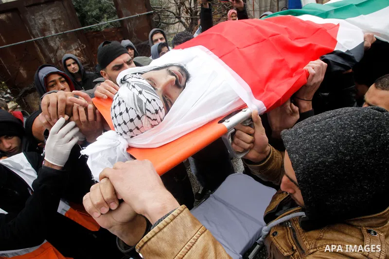 Palestinians carry the body of Fadel Qawasma during his funeral in the West Bank city of Hebron on January 2, 2016. Photo by Wisam Hashlamoun