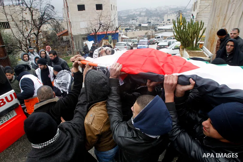 Palestinians carry the body of Fadel Qawasma during his funeral in the West Bank city of Hebron on January 2, 2016. Photo by Wisam Hashlamoun
