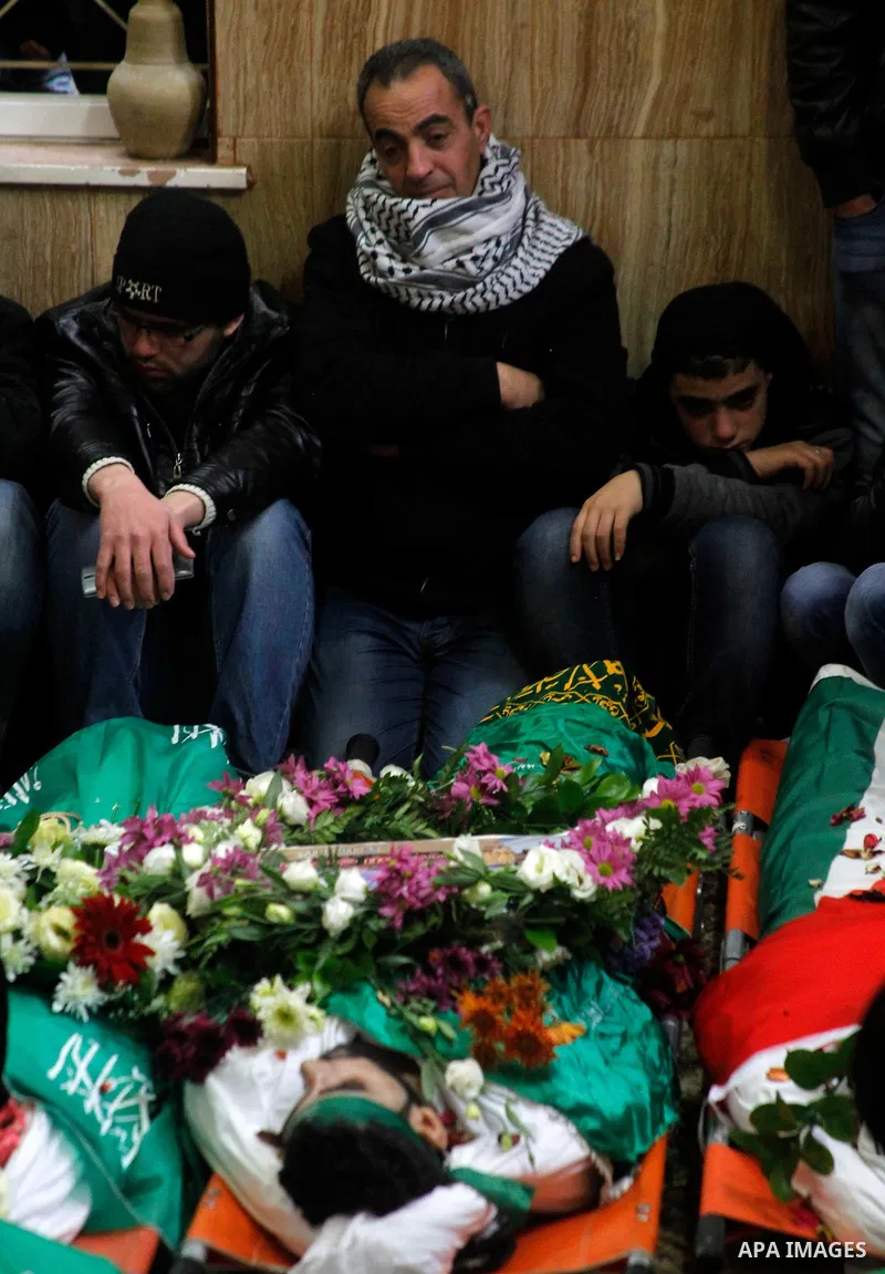 Mourners gather around the bodies of Palestinians, who allegedly carried out attacks against Israelis, during their funeral in the West Bank city of Hebron January 2, 2016. Palestinians received on Friday 23 bodies of al...