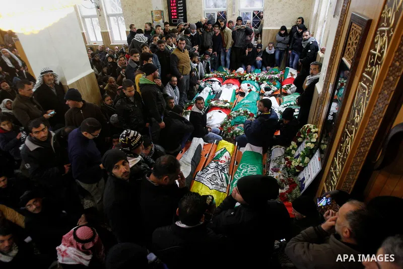 Mourners gather around the bodies of Palestinians, who allegedly carried out attacks against Israelis, during their funeral in the West Bank city of Hebron January 2, 2016. Palestinians received on Friday 23 bodies of al...