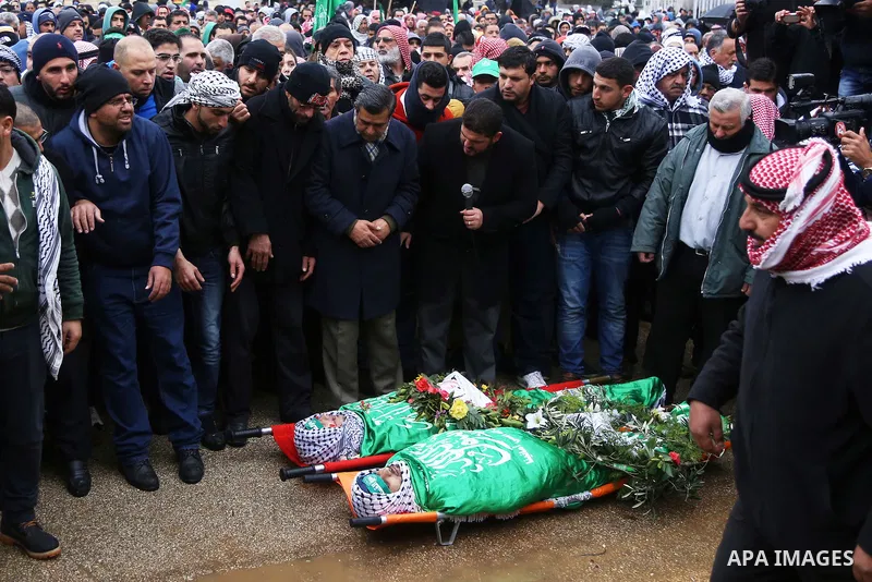 Mourners pray on the bodies of Anas Hammad and Mohammed Ayyad, who allegedly carried out attacks against Israelis, during her funeral in the occupied West Bank village of Silwad, northeast of Ramallah, on January 3, 2016...