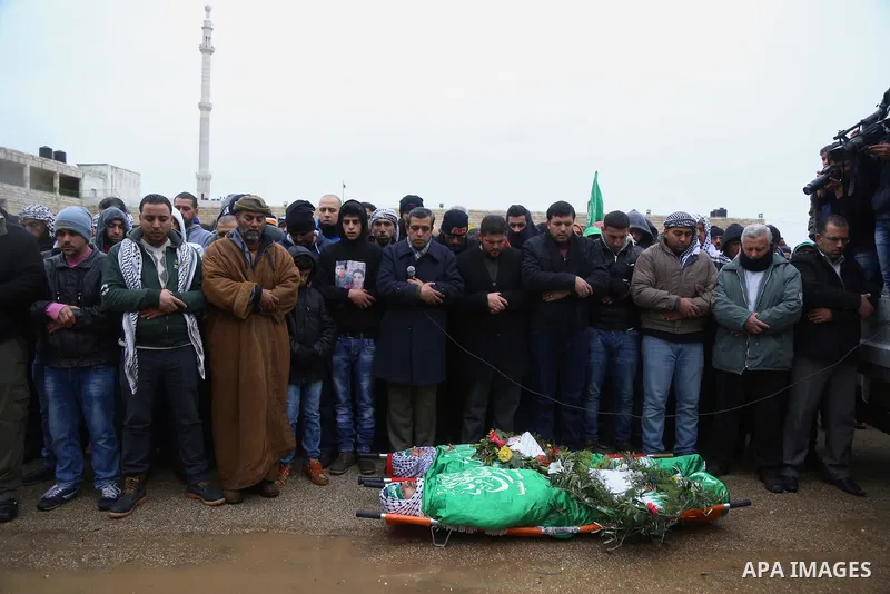Mourners pray on the bodies of Anas Hammad and Mohammed Ayyad, who allegedly carried out attacks against Israelis, during her funeral in the occupied West Bank village of Silwad, northeast of Ramallah, on January 3, 2016...