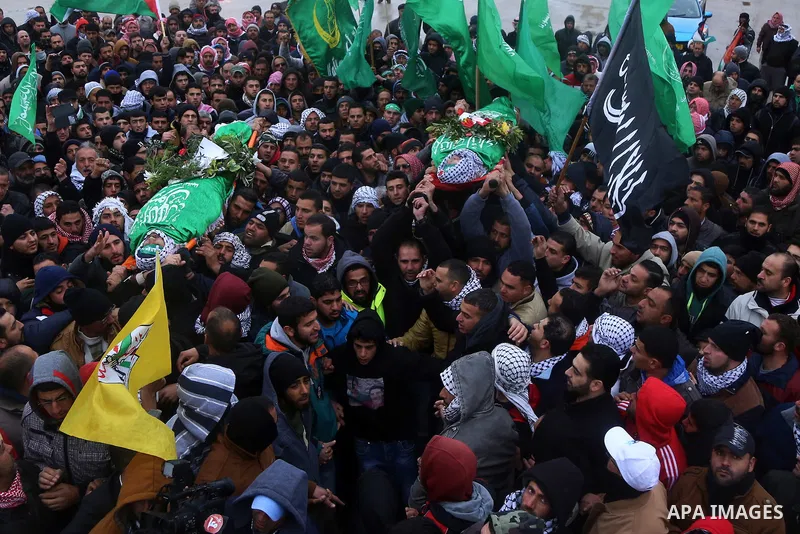 Mourners carry the bodies of Anas Hammad and Mohammed Ayyad, who allegedly carried out attacks against Israelis, during her funeral in the occupied West Bank village of Silwad, northeast of Ramallah, on January 3, 2016....