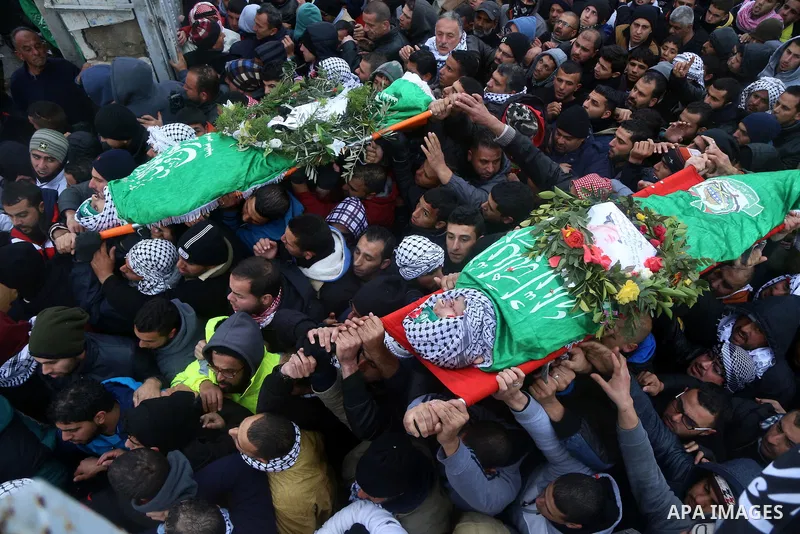 Mourners carry the bodies of Anas Hammad and Mohammed Ayyad, who allegedly carried out attacks against Israelis, during her funeral in the occupied West Bank village of Silwad, northeast of Ramallah, on January 3, 2016....
