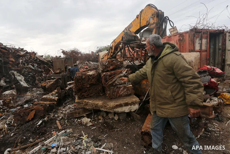 A Palestinian labourer works at workshop for scrap iron compress in Gaza city, on January 3, 2016. Photo by Mohammed Asad