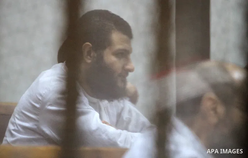 Defendants of Egyptian Muslim Brotherhood sit behind bars during the 'Qatar espionage' case, along with ousted Islamist president Mohamed Morsi (unseen) in a court in Cairo on Jan. 04, 2015. The defendants are accused of...