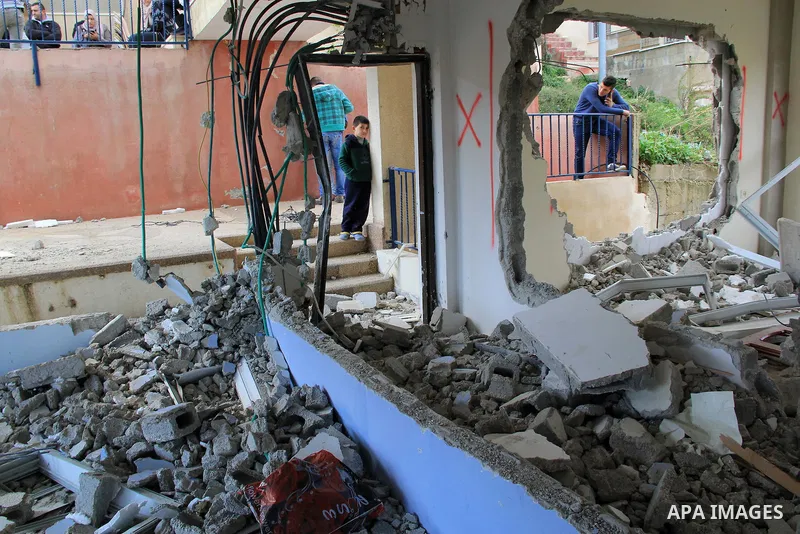 Palestinian men inspect the damaged interior of the home of Bahaa Allyan, a Palestinian who killed three Israelis in a shooting and stabbing attack with an accomplice on a bus in October, after Israeli forces used jackha...