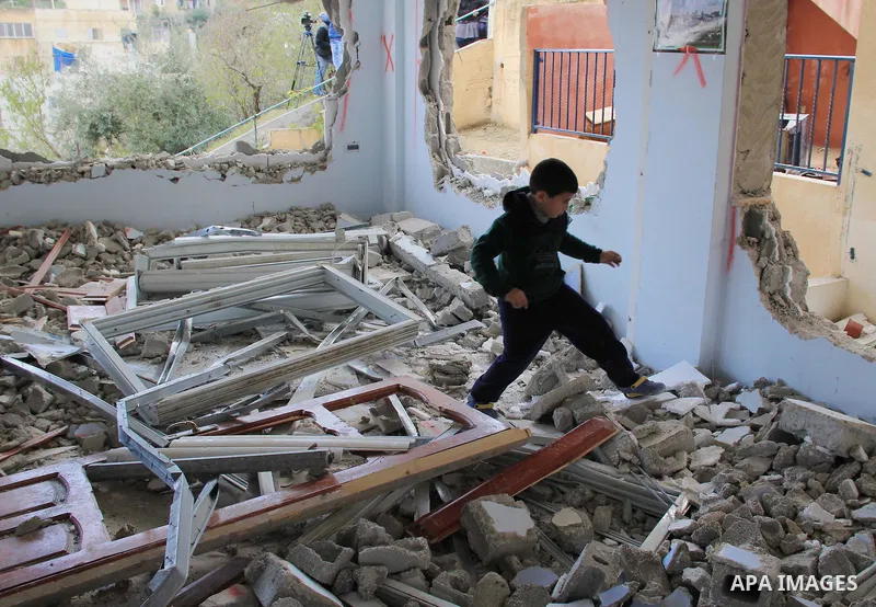 A Palestinian boy inspects the damaged interior of the home of Bahaa Allyan, a Palestinian who killed three Israelis in a shooting and stabbing attack with an accomplice on a bus in October, after Israeli forces used jac...
