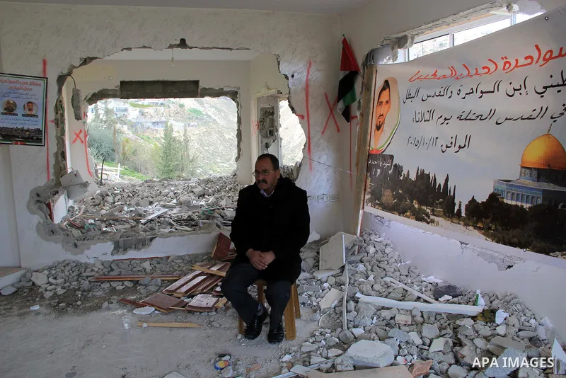 Palestinian men inspect the damaged interior of the home of Bahaa Allyan, a Palestinian who killed three Israelis in a shooting and stabbing attack with an accomplice on a bus in October, after Israeli forces used jackha...