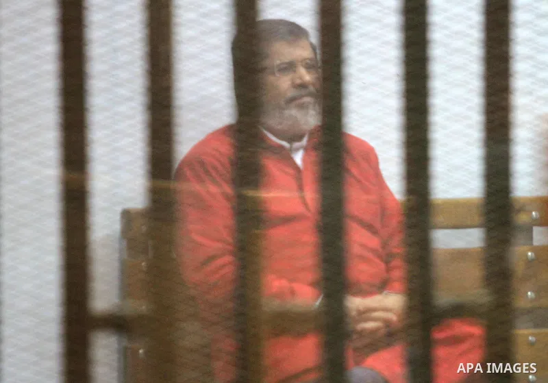 Ousted Egyptian president Mohammed Morsi sits behind bars during his trail as part of the so-called 'Qatar espionage' case, in a court in Cairo on Jan. 04, 2016. The defendants are accused of 'leaking important national...