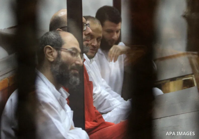 Defendants of Egyptian Muslim Brotherhood sit behind bars during the 'Qatar espionage' case, along with ousted Islamist president Mohamed Morsi (unseen) in a court in Cairo on Jan. 04, 2016. The defendants are accused of...