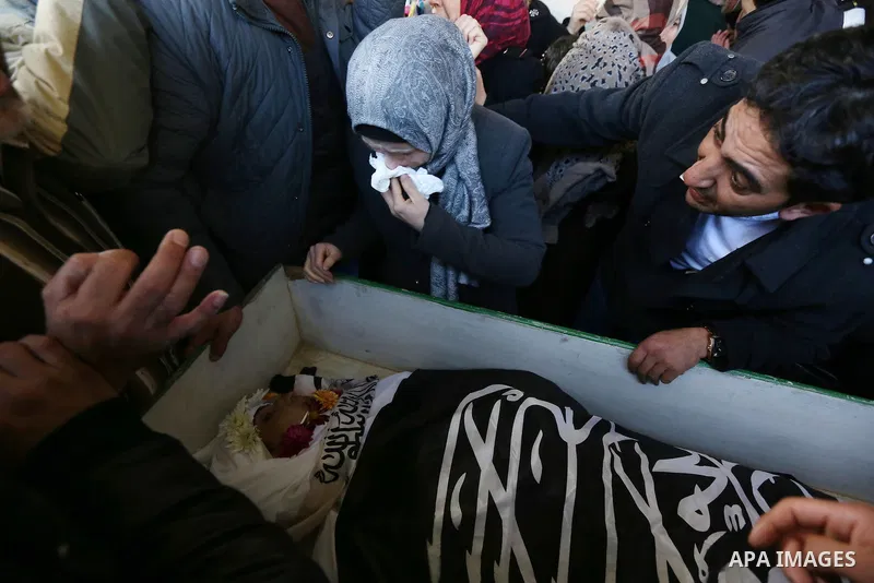 Mourners gather around the bodies of Palestinian Ishaq Badran and Ahmed Quneibi, who allegedly carried out attacks against Israelis, after their bodies were released by Israel, during their funeral in the West Bank city...