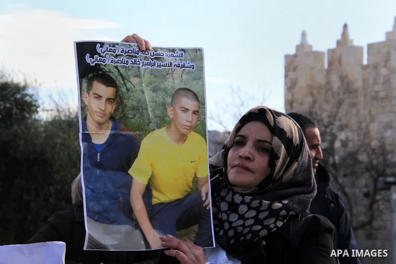 A Palestinian woman holds a placard with pictures of Palestinian attackers from East Jerusalem who were killed by Israeli security forces while carrying attacks against Israelis in the recent wave of violence, during a p...
