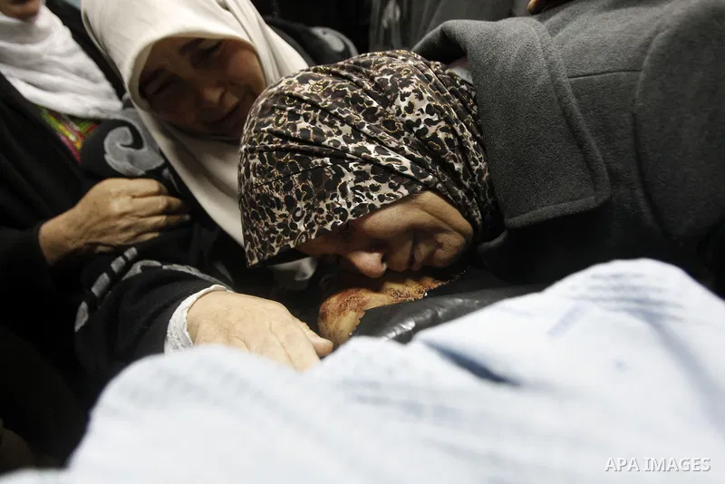The mother of 18-year-old Palestinian Ahmad Younis Kawazba kisses his head at a hospital in the West Bank city of Hebron on Jan. 05, 2016. Kawazba was shot dead after he reportedly stabbed an Israeli soldier at the Gush...