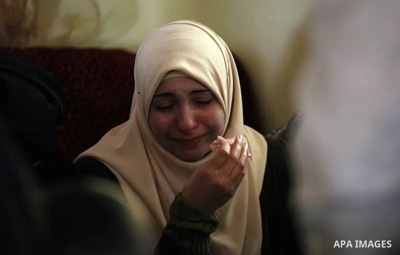 Mourners gather around on the body of Palestinian Ahmad Kawazbeh, 17, whom the Israeli military said was shot and killed by Israeli security forces on Tuesday after he stabbed an Israeli soldier, during his funeral in th...