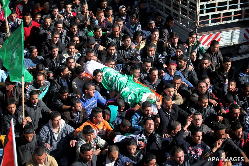 Mourners carry the body of Palestinian Ahmad Kawazbeh, 17, whom the Israeli military said was shot and killed by Israeli security forces on Tuesday after he stabbed an Israeli soldier, during his funeral in the West Bank...