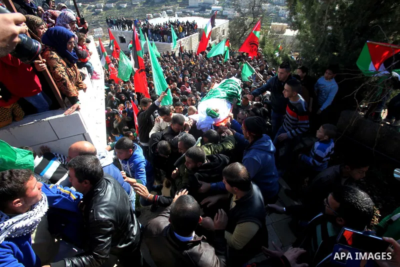 Mourners carry the body of Palestinian Ahmad Kawazbeh, 17, whom the Israeli military said was shot and killed by Israeli security forces on Tuesday after he stabbed an Israeli soldier, during his funeral in the West Bank...