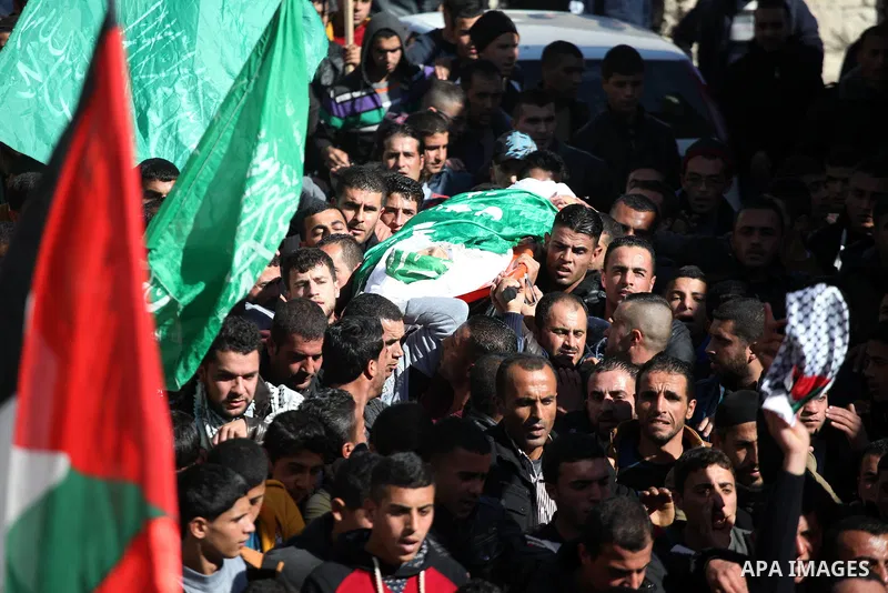 Mourners carry the body of Palestinian Ahmad Kawazbeh, 17, whom the Israeli military said was shot and killed by Israeli security forces on Tuesday after he stabbed an Israeli soldier, during his funeral in the West Bank...