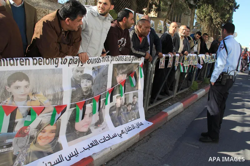 Palestinians take part in a protest to show solidarity with two Palestinian children, Muawiya Alqam,14, and his brother Ali,11, during their trial, outside an Israeli court in Jerusalem on January 6, 2016. Ali and Muawiy...