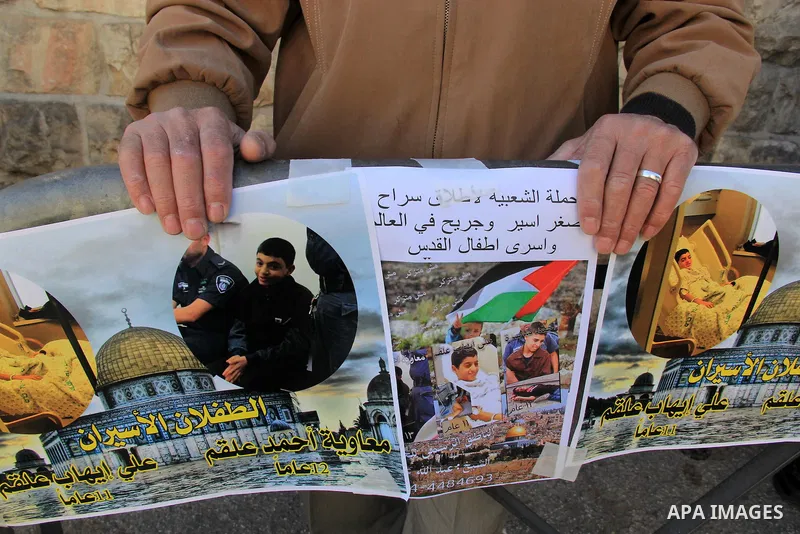 Palestinians take part in a protest to show solidarity with two Palestinian children, Muawiya Alqam,14, and his brother Ali,11, during their trial, outside an Israeli court in Jerusalem on January 6, 2016. Ali and Muawiy...