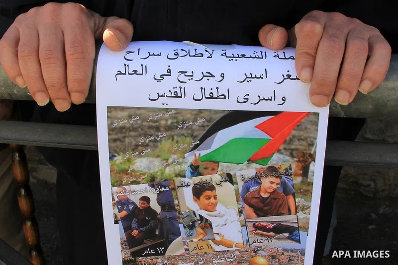 Palestinians take part in a protest to show solidarity with two Palestinian children, Muawiya Alqam,14, and his brother Ali,11, during their trial, outside an Israeli court in Jerusalem on January 6, 2016. Ali and Muawiy...