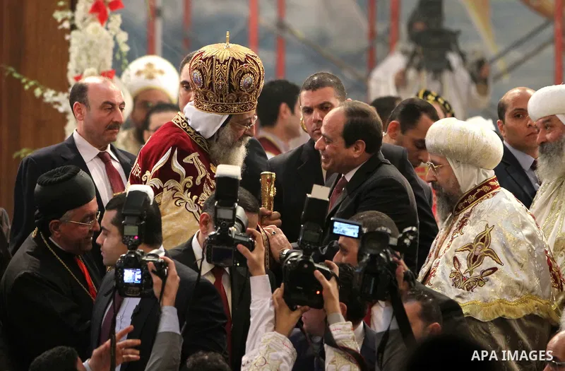 Egyptian President Abdel Fattah el-Sisi waves to the worshipers during his visit to the St. Mark's Coptic Orthodox Cathedral on the eve of the orthodox Christmas mass led by Egyptian Coptic Pope Tawadros II in Cairo on J...