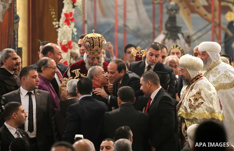 Egyptian President Abdel Fattah el-Sisi waves to the worshipers during his visit to the St. Mark's Coptic Orthodox Cathedral on the eve of the orthodox Christmas mass led by Egyptian Coptic Pope Tawadros II in Cairo on J...