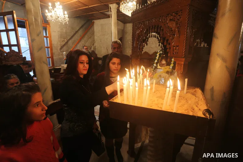Palestinian Greek Orthodox Christians attend Christmas mass at the Orthodox Saint Porfirios church in Gaza City on January 7, 2016. The Orthodox Church celebrates Christmas and other religious holidays according to the J...