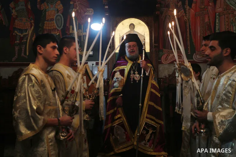 Palestinian Greek Orthodox Christians attend Christmas mass at the Orthodox Saint Porfirios church in Gaza City on January 7, 2016. The Orthodox Church celebrates Christmas and other religious holidays according to the J...