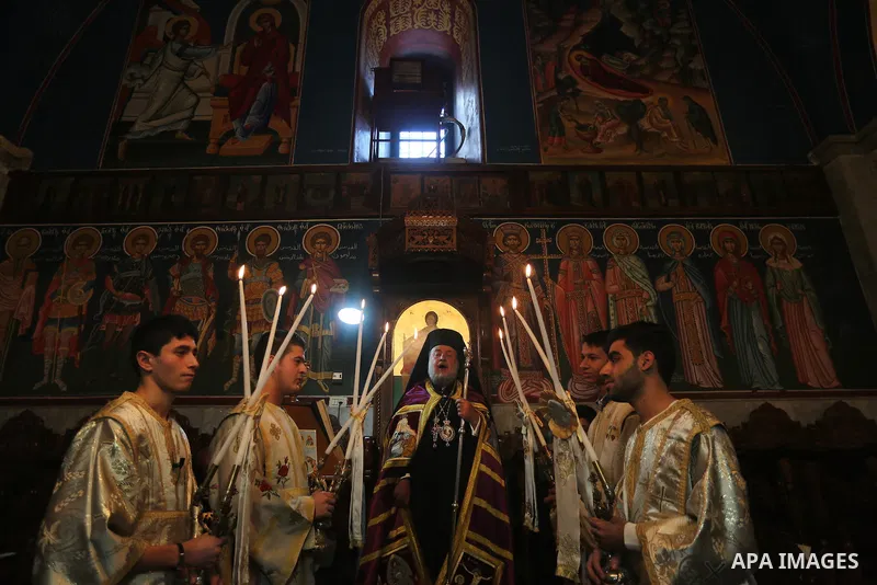 Palestinian Greek Orthodox Christians attend Christmas mass at the Orthodox Saint Porfirios church in Gaza City on January 7, 2016. The Orthodox Church celebrates Christmas and other religious holidays according to the J...