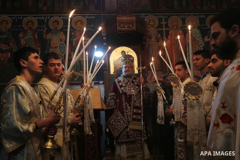 Palestinian Greek Orthodox Christians attend Christmas mass at the Orthodox Saint Porfirios church in Gaza City on January 7, 2016. The Orthodox Church celebrates Christmas and other religious holidays according to the J...