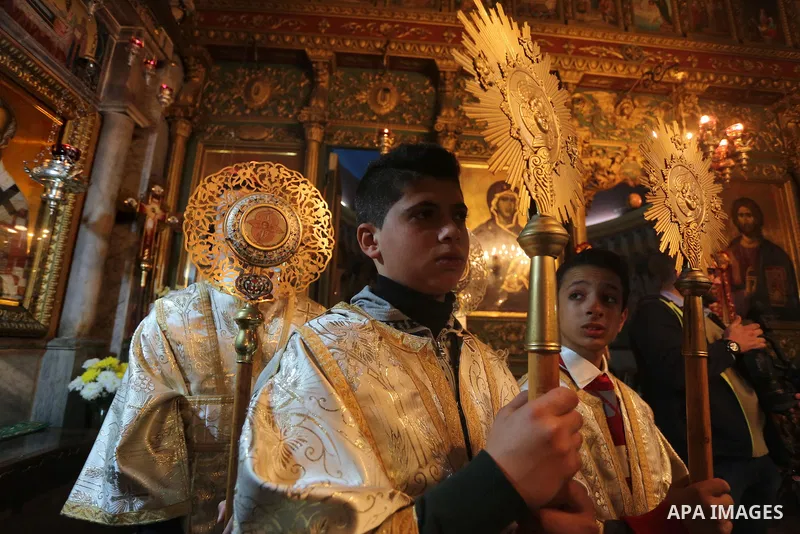 Palestinian Greek Orthodox Christians attend Christmas mass at the Orthodox Saint Porfirios church in Gaza City on January 7, 2016. The Orthodox Church celebrates Christmas and other religious holidays according to the J...