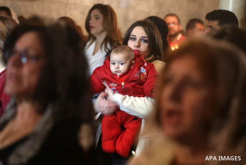 Palestinian Greek Orthodox Christians attend Christmas mass at the Orthodox Saint Porfirios church in Gaza City on January 7, 2016. The Orthodox Church celebrates Christmas and other religious holidays according to the J...