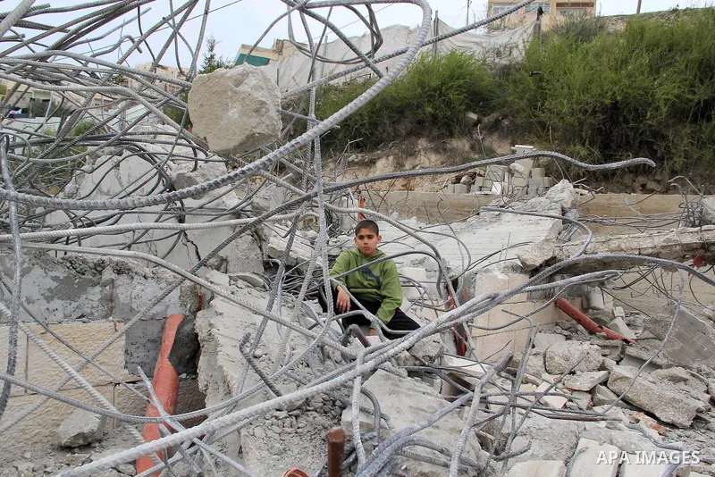 A Palestinian boy stands on the rubble of his family house that was demolished by Jerusalem municipality workers in Jerusalem on Jan. 07, 2016. Israeli police Thursday demolished two Palestinian-owned homes in Ein el-Law...