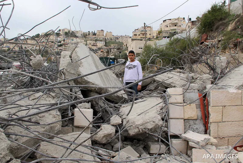 A Palestinian boy stands on the rubble of his family house that was demolished by Jerusalem municipality workers in Jerusalem on Jan. 07, 2016. Israeli police Thursday demolished two Palestinian-owned homes in Ein el-Law...