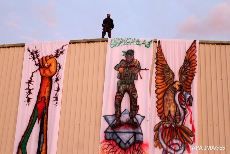 A Palestinian loyal to the Hamas movement watches a rally in Khan Yunis in the southern Gaza Strip on January 7, 2016. The rally was held to honor the families of dead militants from the armed wing, who Hamas said partic...