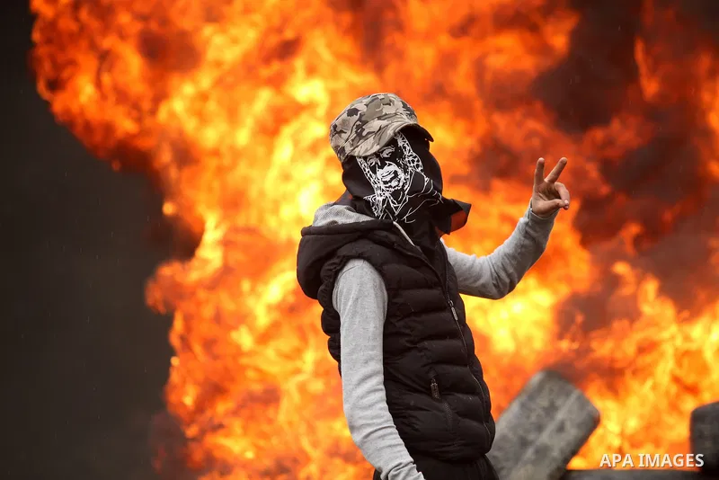 A Palestinian protester flashes victory sign during clashes with Israeli security forces following a protest against the expropriation of Palestinian land by Israel in the West Bank village of Kafr Qaddum, near the north...