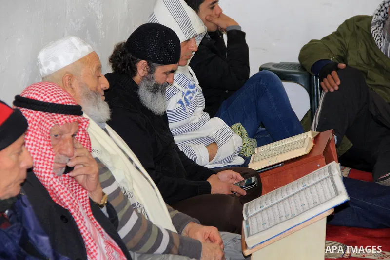 Palestinian Muslim worshipers read a holy Quran following Friday prayers at al-Aqsa mosque, Islam's third holiest site, in Jerusalem's Old city on Jan. 08, 2016. Photo by Mahfouz Abu Turk