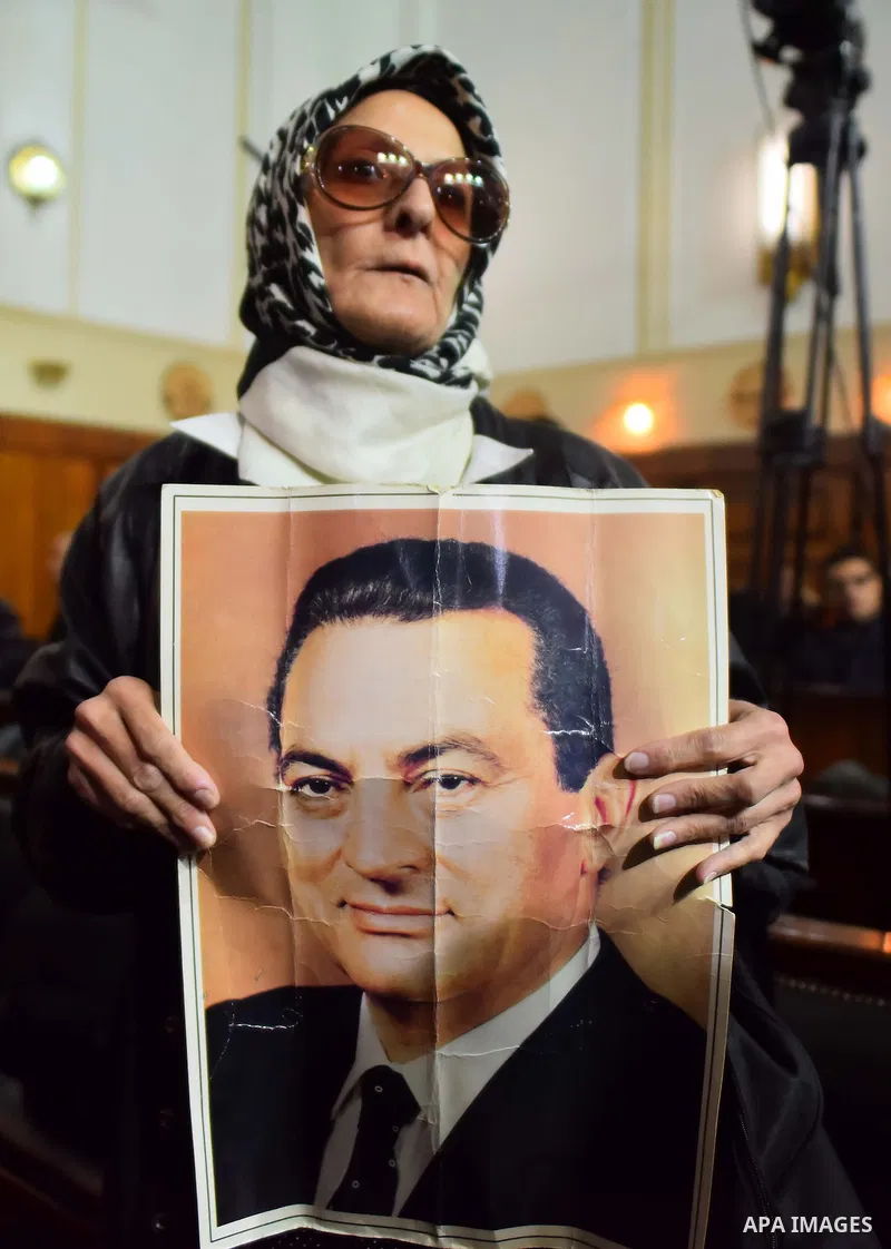 Egyptian supporters of ousted president Hosni Mubarak react inside the courtroom in Cairo on January 9, 2016, after top appeals court upheld upheld a three-year prison sentence for Mubarak and his two sons for corruption...