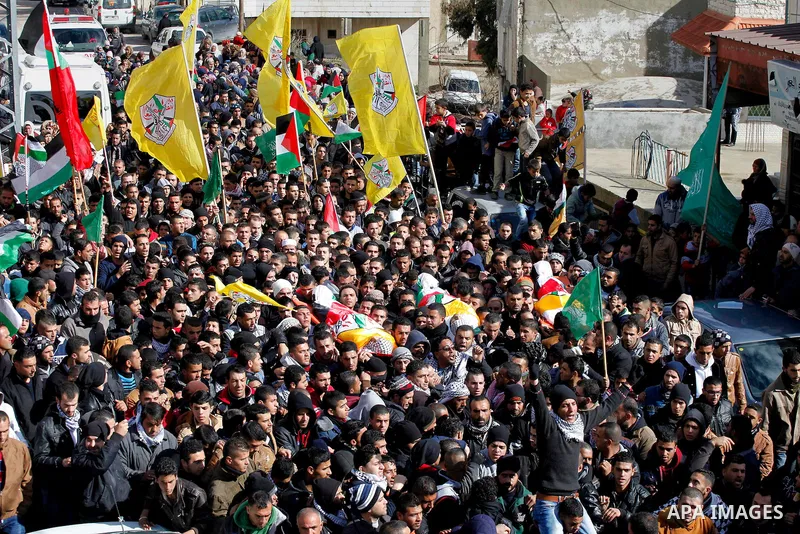 Mourners carry the bodies of four Palestinians, who were killed by Israeli security forces after they perpetrated attacks in the southern West Bank, during their funeral in the West Bank village of Sair on January 9, 201...