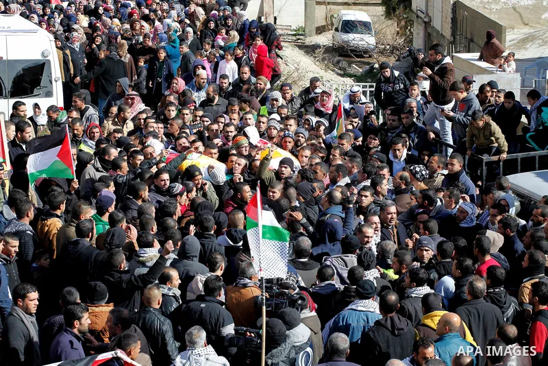 Mourners carry the bodies of four Palestinians, who were killed by Israeli security forces after they perpetrated attacks in the southern West Bank, during their funeral in the West Bank village of Sair on January 9, 201...
