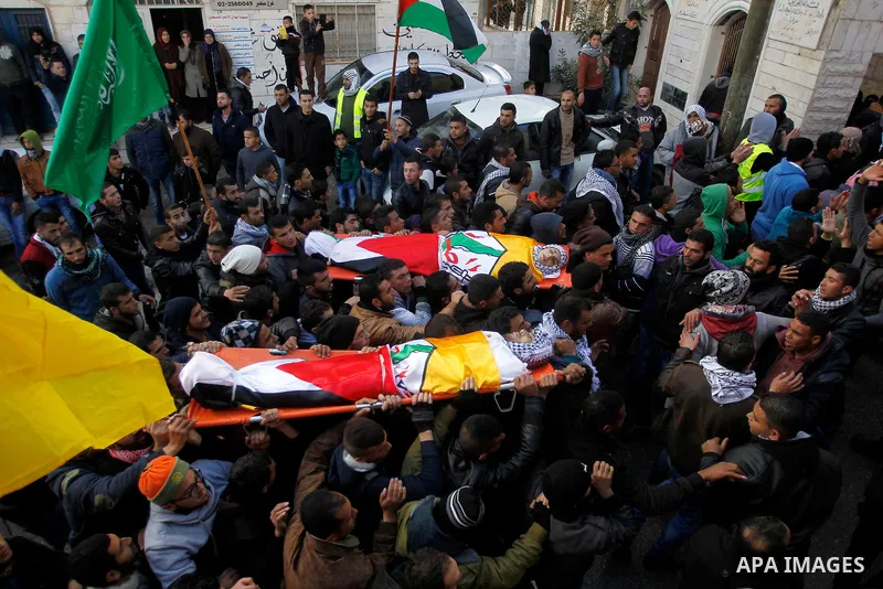 Mourners carry the bodies of four Palestinians, who were killed by Israeli security forces after they perpetrated attacks in the southern West Bank, during their funeral in the West Bank village of Sair on January 9, 201...