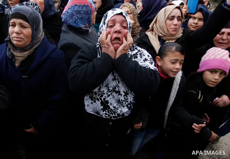 Relatives of one of four Palestinians, who were killed by Israeli security forces after they perpetrated attacks in the southern West Bank, mourn during their funeral in the West Bank village of Sair on January 9, 2016,...