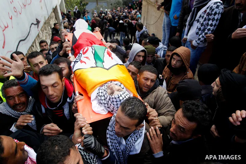 Mourners carry the bodies of four Palestinians, who were killed by Israeli security forces after they perpetrated attacks in the southern West Bank, during their funeral in the West Bank village of Sair on January 9, 201...
