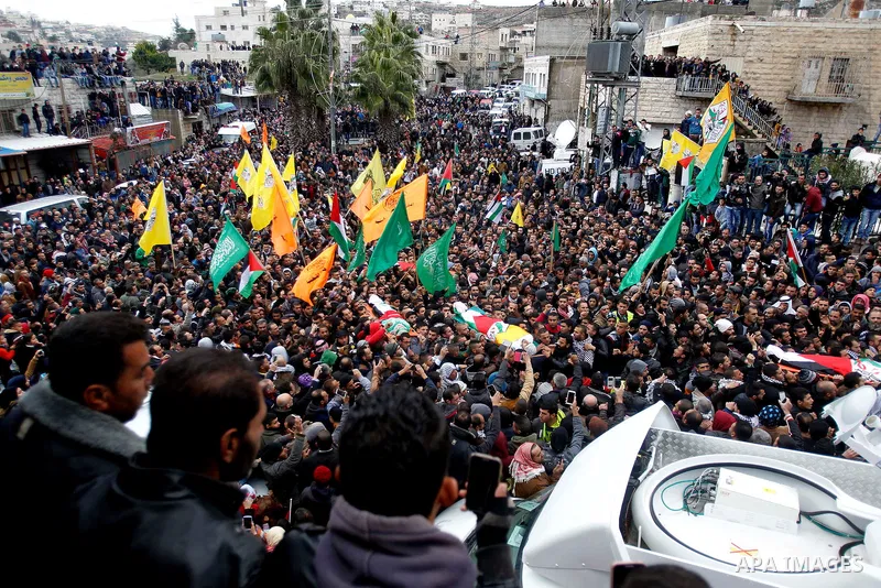 Mourners carry the bodies of four Palestinians, who were killed by Israeli security forces after they perpetrated attacks in the southern West Bank, during their funeral in the West Bank village of Sair on January 9, 201...
