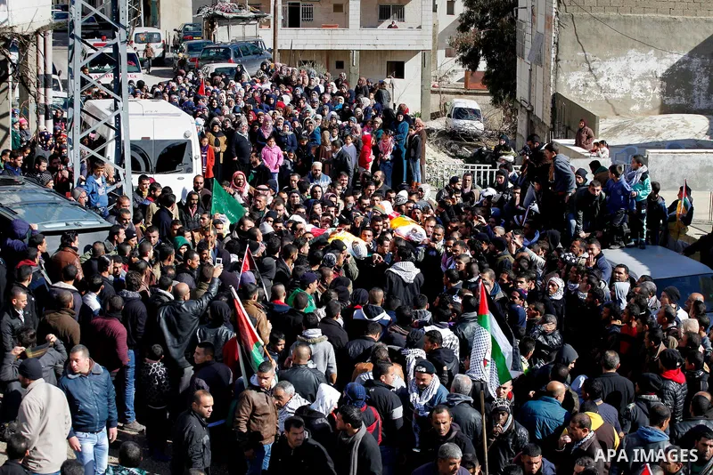 Mourners carry the bodies of four Palestinians, who were killed by Israeli security forces after they perpetrated attacks in the southern West Bank, during their funeral in the West Bank village of Sair on January 9, 201...