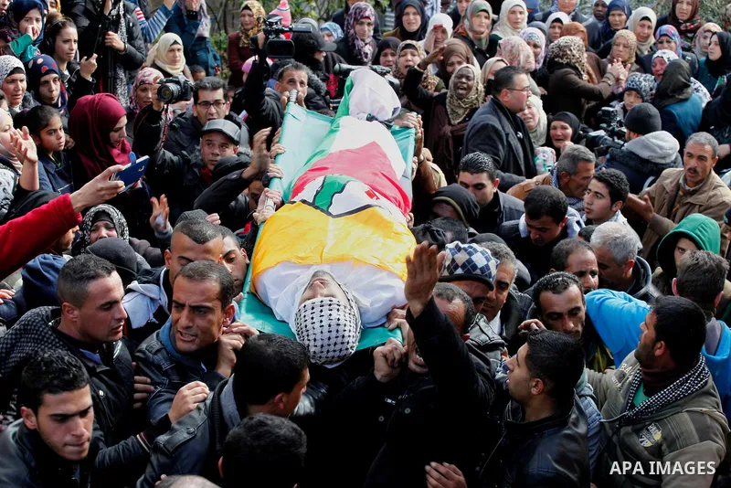 Mourners carry the bodies of four Palestinians, who were killed by Israeli security forces after they perpetrated attacks in the southern West Bank, during their funeral in the West Bank village of Sair on January 9, 201...