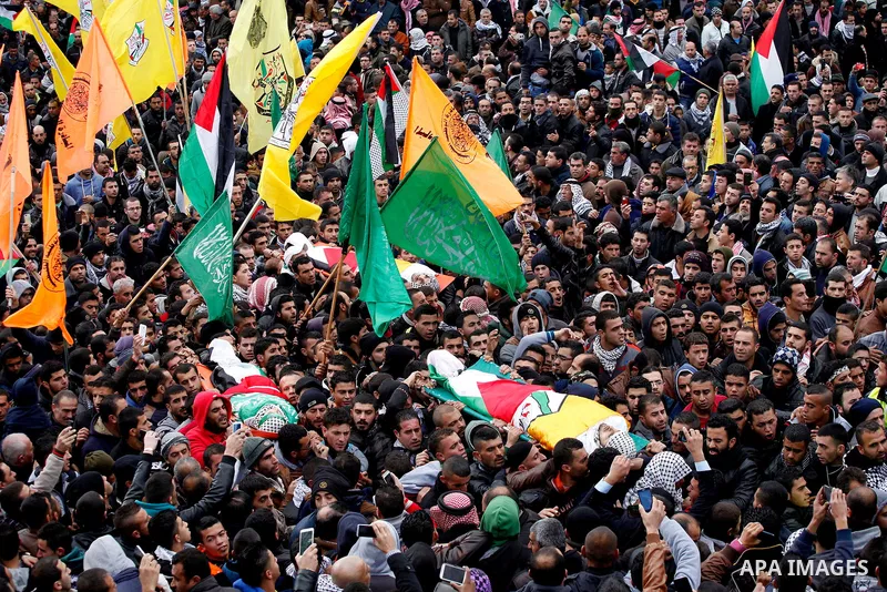 Mourners carry the bodies of four Palestinians, who were killed by Israeli security forces after they perpetrated attacks in the southern West Bank, during their funeral in the West Bank village of Sair on January 9, 201...
