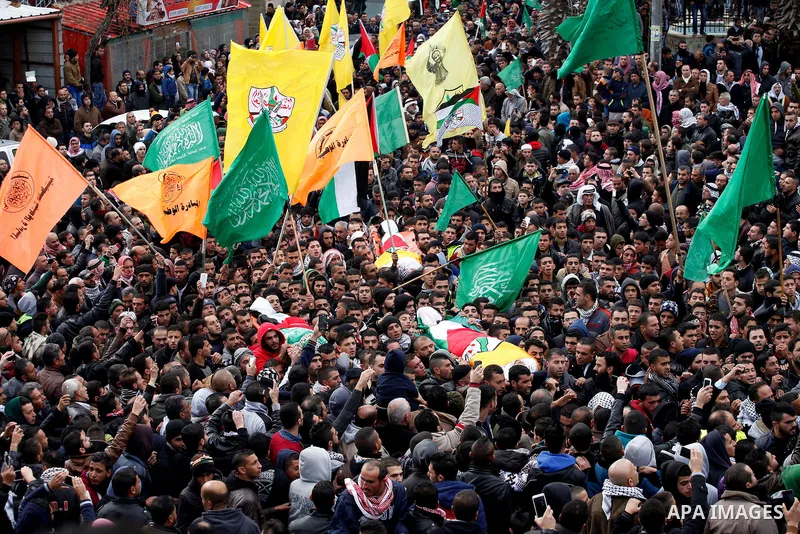 Mourners carry the bodies of four Palestinians, who were killed by Israeli security forces after they perpetrated attacks in the southern West Bank, during their funeral in the West Bank village of Sair on January 9, 201...