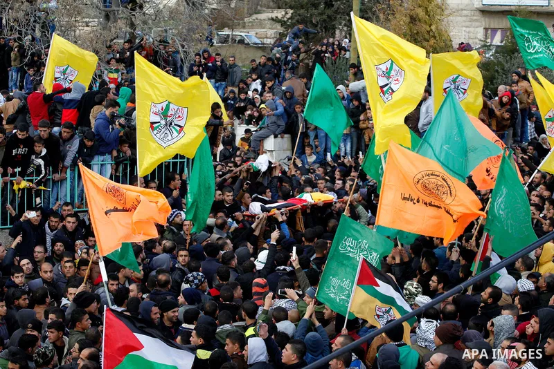 Mourners carry the bodies of four Palestinians, who were killed by Israeli security forces after they perpetrated attacks in the southern West Bank, during their funeral in the West Bank village of Sair on January 9, 201...